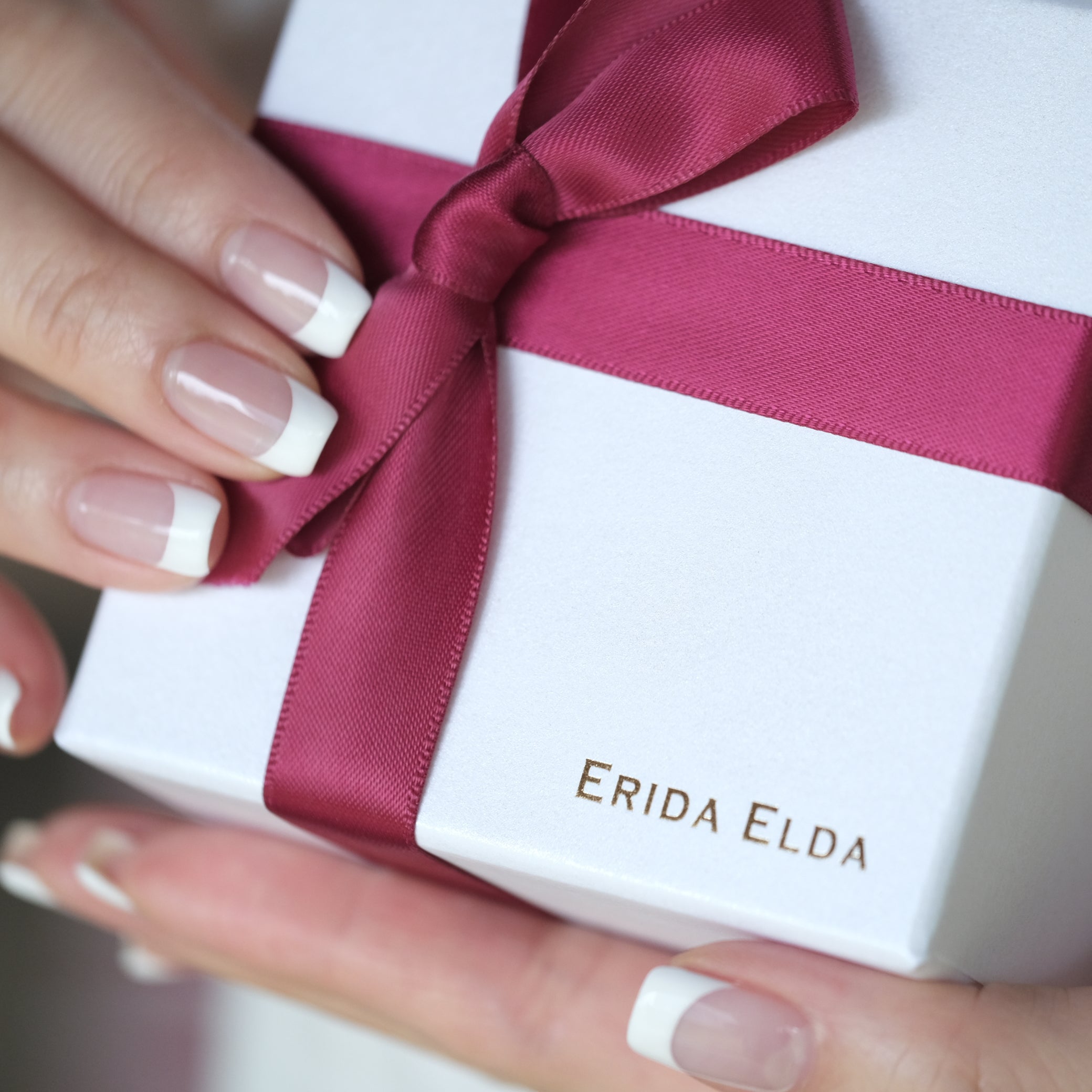 ホワイトフレンチネイルの女性がERIDA ELDAのジュエリーボックスを持つ上品な手元