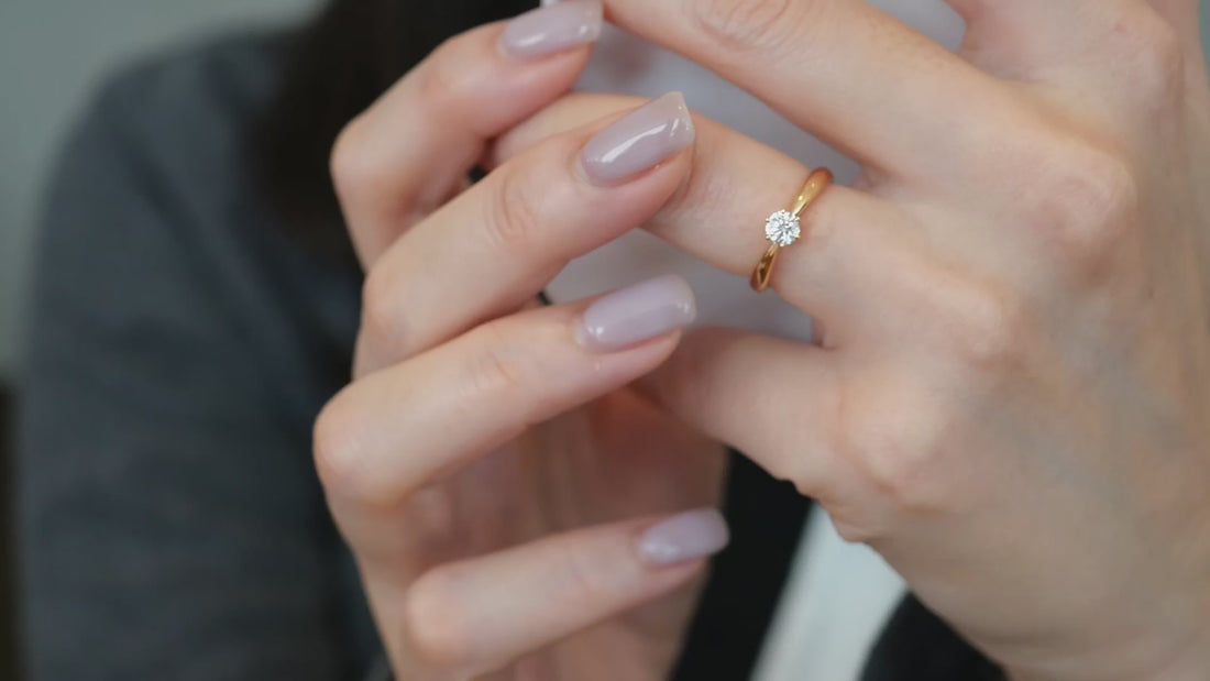 日常の中で携帯を持つ手に輝くエリーダエルダのローズゴールド一粒ダイヤモンドリング。自然に溶け込む輝き
