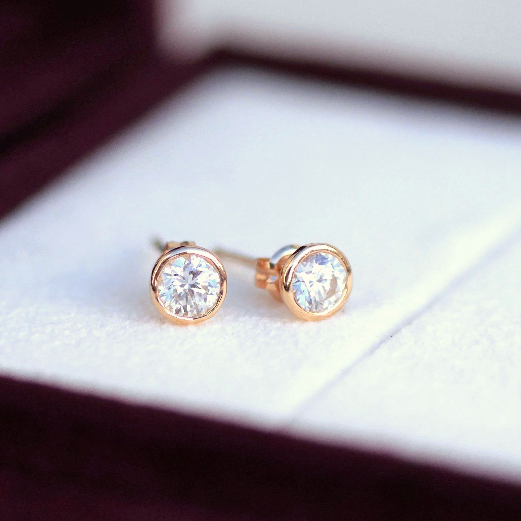 ローズゴールドの枠にセットされた一粒ダイヤモンドピアス。丸みのあるベゼルセッティングが柔らかい光を放つK18ジュエリー。