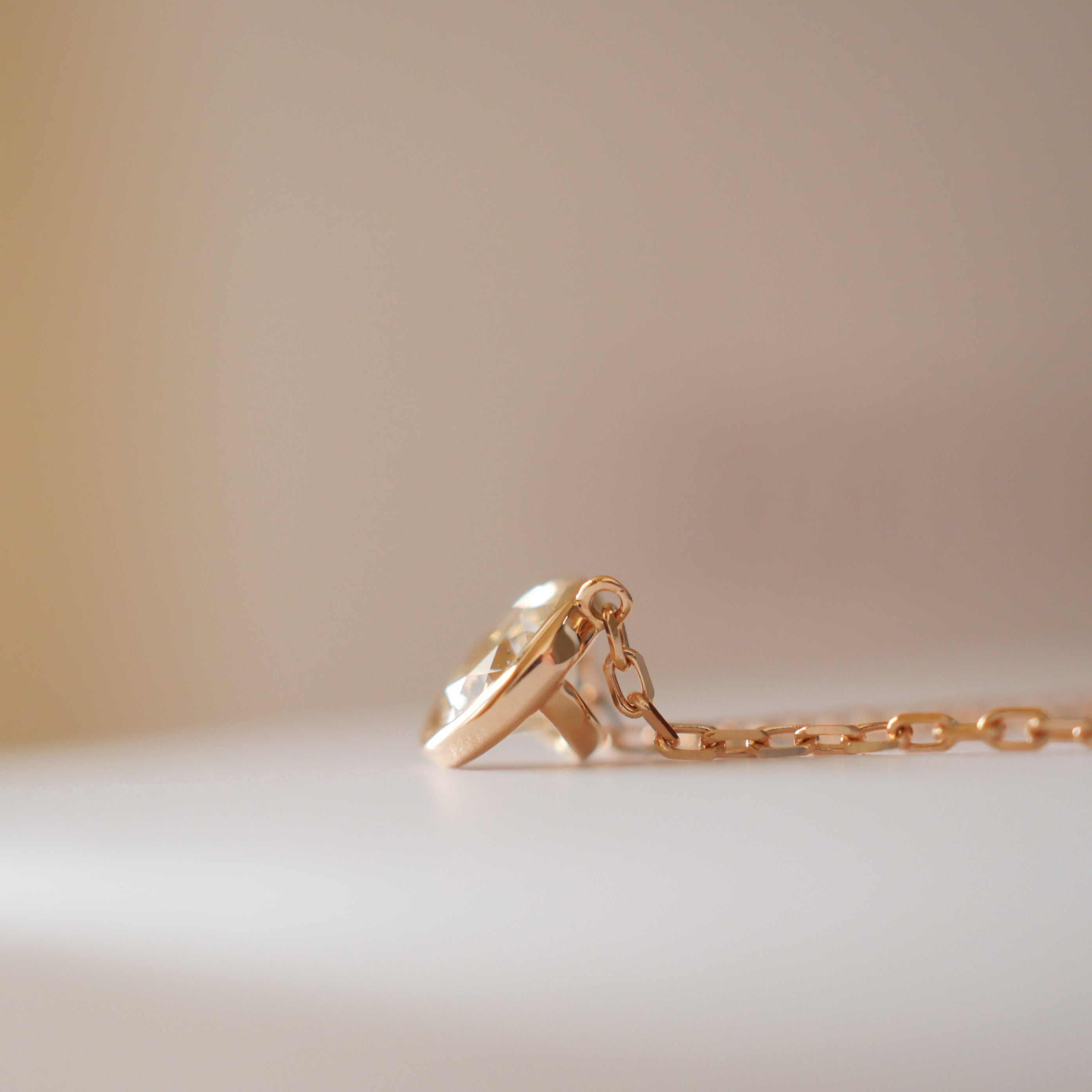 余計な地金をそぎ落とし光を取り込むデザインのローズゴールド天然ダイヤモンドネックレス。斜め45度の輝き